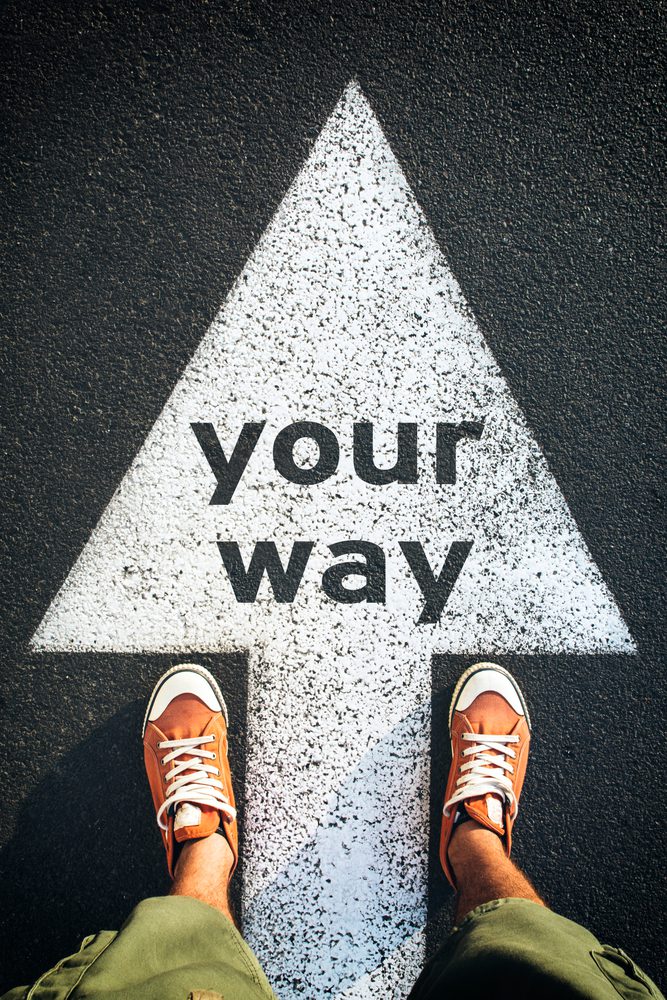 Red shoes standing on your way sign